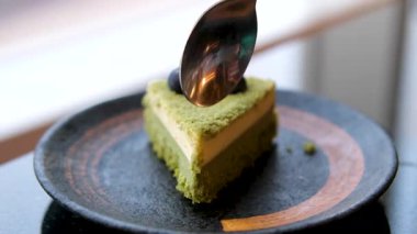 Bir kadın çatalla kibritli pastadan bir ısırık alıyor. Kiraz keki ya da yeşil çay keki kiraz tozu ile tatlandırılmış hafif ve yumuşak bir sünger kektir. Yüksek kalite 4k görüntü