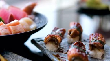 Yılanbalığı suşisi, sashimi Nigiri Tabağı, Japon suşi restoranı, Taze Ton Balığı ve Somon Dilimleri modern kafede, geleneksel yemek, çiğ kırmızı balık yemeği, omega 3. Yüksek kalite 4k görüntü
