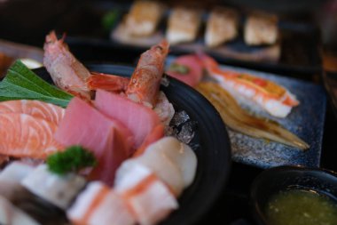 Suşi tabağı deniz ürünleri suşi tabağı içinde çeşitli taze nigiri ve dürümler var. Beyaz bir tabakta güzelce sunuluyor. Japon mutfağını vurgulamak için mükemmel yemek deneyimleri.