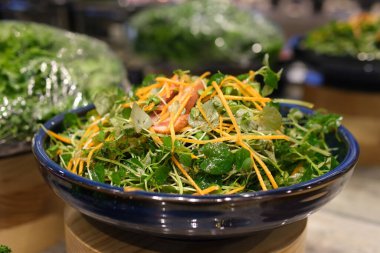 Lezzetli taze salatayı beyaz tabağa koy. Sağlıklı lezzetli salata, ıspanak, çilek, avokado, fındık. Hizmet süreci.