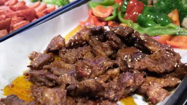 Sulu büyük bir dilim biftek ya da ızgara sebzeli koyun eti ızgara biberli kabak domatesleri ve beyaz bir tabakta taze biberiye filizi ile süslenmiş mantarlar, tabağın etrafında dönmesi. 