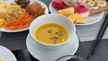 Lüks bir restoranda kahvaltı balkabağı kremalı çorba meyveli sandviç fıstık ezmeli ve muzlu kızarmış havuçlu pilav. Yüksek kalite 4k görüntü