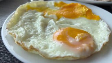 Tavada kızarmış yumurta pişirmek. Üç yumurta beyazı ve sarısı. Kahvaltıda omlet. Teflonsuz kızartma tavası. Sporcular için sağlıklı beslenme, protein diyeti. Yüksek kalite 4k görüntü