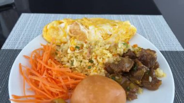 Bir tabak rendelenmiş havuç pirinçli kızarmış yumurta tatlı olarak fıstık ezmeli muzlu jöle ve lüks bir otel kahvaltısında meyveli sandviç. Yüksek kalite 4k görüntü