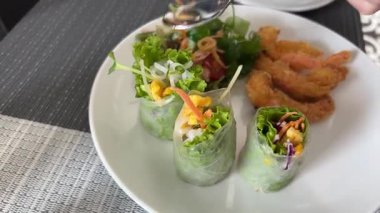 Vietnam yemeğinin üzerine balık sosu dök. Plastik kutuda domuz karides salatası ruloları. Vietnam yemekleri. Vietnam usulü karides salatası dürümleri. Yüksek kalite 4k görüntü