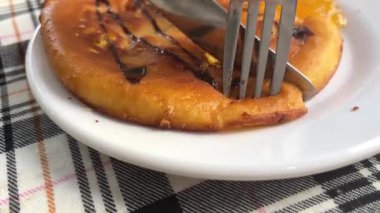 Lokantada bir kadın üzerine çikolata konmuş, kiraz ve şeftali süslemeli krep yiyor. Yakın plan. Yüksek kalite 4k görüntü