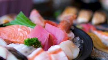 Sashimi Tabağı, Japon suşi restoranı, Taze Ton Balığı ve Somon Dilimleri modern kafede geleneksel yemekler, çiğ kırmızı balık yemeği, omega 3. Yüksek kalite 4k görüntü