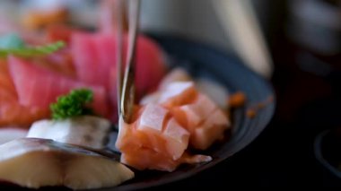 Taze Japon saşimi tabağı, çiğ balık, garnitürlü kase, suşi mutfağı, iştah açıcı sunum, deniz ürünleri lezzeti. Yüksek kalite 4k görüntü