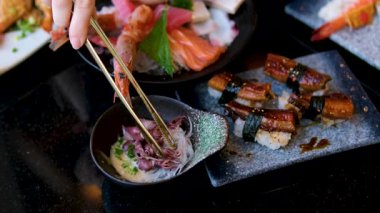 Yılan balığı suşisi küçük ahtapotlar çeşitli suşiler ve tabakta sergilenen deniz ürünleri. Yüksek kalite 4k görüntü