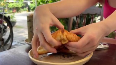 Bir kadının elleri taze pişmiş bir turtayı ikiye böler. Kıtır kıtır. Kruvasan hamur dokusunu kır