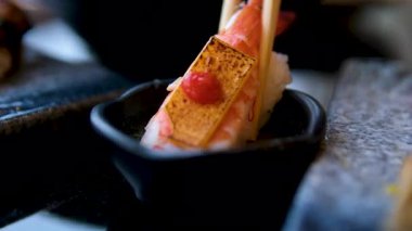 Yemek çubuklarını kullanamamak suşi parçalanmış, rulo sosa batırılmış, kötü bir çekim. Yüksek kalite 4k görüntü