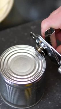 Konserve açacağıyla bir kutu mısır gevreği açmak. Konserve mısırlı metal teneke kutu. Yüksek kalite 4k görüntü