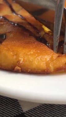 Lokantada bir kadın üzerine çikolata konmuş, kiraz ve şeftali süslemeli krep yiyor. Yakın plan. Yüksek kalite 4k görüntü