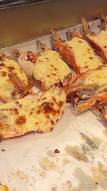 Biz usta bir şekilde ağız sulandırıcı karides ızgarası hazırlarken... -... üzerine yapışkan peynir sosu dökülmüş. Hareketli pazarlardan, cızırdayan ızgaralara, deniz ürünlerinin lezzetini tecrübe edin. 