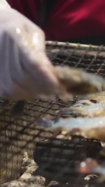 Izgarada ızgara karides ve mangal. Yağlı tavada kızartılan karideslerin yakın çekimi. Yüksek kalite 4k görüntü