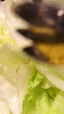 Parlak bir mutfak ortamında taze sebzelerle renkli bir salata toplanıyor. Yüksek kalite 4k görüntü