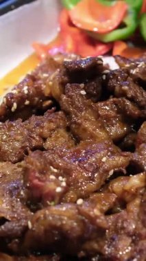 Sulu büyük bir dilim biftek ya da ızgara sebzeli koyun eti ızgara biberli kabak domatesleri ve beyaz bir tabakta taze biberiye filizi ile süslenmiş mantarlar, tabağın etrafında dönmesi. 