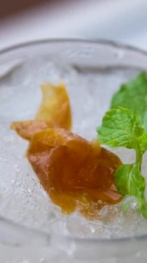 Limon, nane ve suda yüzen zencefil. Taze sarı limonlar beyaz arka planda köpüklerle suya düşüyorlar. Citrus meyveleri kabarcıklarla suya düşüyor. Yavaş çekim yakın çekim. Yüksek kalite 4k