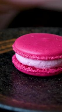 Lezzetli bir kızın ellerinde tatlı ile lezzetli bir makarna. Lezzetli bir kafe pembe ahududu şam fıstığı. Yüksek kalite 4k görüntü