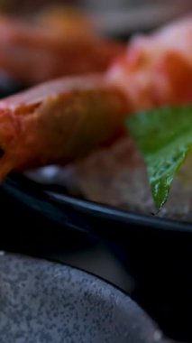 Soslu sebzeli lezzetli karidesler. Restoranda egzotik Vietnam yemekleri menüsü. Deniz ürünleri yemeği. Siyah taş tabakta fesleğen ve limonlu haşlanmış karides. Yukarıdan bak. Deniz ürünleri..