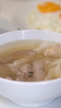 Taze yapılmış pho çorbası fasulye lahanası ve fesleğen yapraklarıyla süslenir. Kadın sıcak Asya çorbasının tadını arttıran malzemeler ekler. Geleneksel Vietnam çorbası, mis kokulu çorba ve taze bitkilerle birlikte..