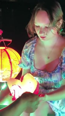 Kız gün batımında nehrin eski kasabasına ya da Hoian antik kasabasına fener fırlatıyor. Hoai Nehri 'nin tepesinde kraliyet bonosu yok. En popüler turistik yerlerden biri. Vietnam Hoi 05.03.2025