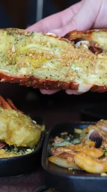 Sebzeli ızgara ıstakoz, canlı tabaklar, deniz ürünleri yeme deneyimi. Yarım bir ıstakozu elimde tutuyorum.