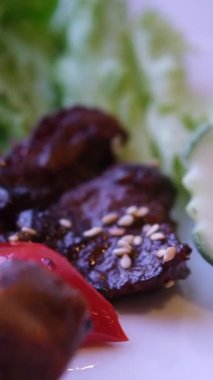 Et yemeği: yeşil kare tabakta büyük ızgara biftek, acı biber ve vişneli domates. Yüksek kalite 4k görüntü