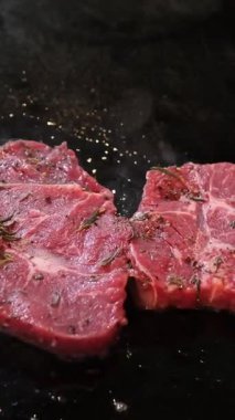 Biftek ızgara ızgara ızgarasında. Izgarada kızartılmış balta bifteği. Izgara barbekü eti. Bifteğin üstünde duman yükseliyor. Yüksek kalite 4k görüntü