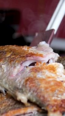 Restorandaki masada kızarmış at uskumrusu tabağı ve limon suyu sıkan bir kadın, yemeğin tadını çıkarmaya hazır. Yüksek kalite 4k görüntü