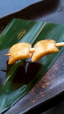 Koyu bir tabakta lezzetli bir sosa batırılan ızgara şişler. Yüksek kalite 4k görüntü