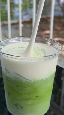 Eller, saman ve sabah içkisi için Matcha ile kafede bir adam dizüstü bilgisayarında serbest yaratıcı bir proje. Karıştır, bilgisayar ve erkek gazeteci kahvedeki enerji artışı için buzlu yeşil sütlü kahve ile 