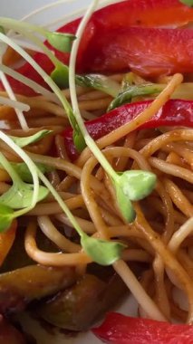 Ahşap zemin üzerinde beyaz bir tabakta deniz mahsulü ile udon karıştırılmış erişteler. Üst Manzara. Yüksek kalite 4k görüntü