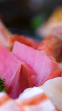 Sashimi Tabağı, Japon suşi restoranı, Taze Ton Balığı ve Somon Dilimleri modern kafede geleneksel yemekler, çiğ kırmızı balık yemeği, omega 3. Yüksek kalite 4k görüntü