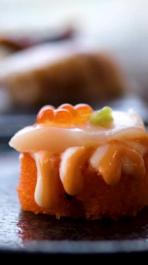 Beyaz bir tabakta servis edilen gurme somon suşi ruloları. Yüksek kalite 4k görüntü