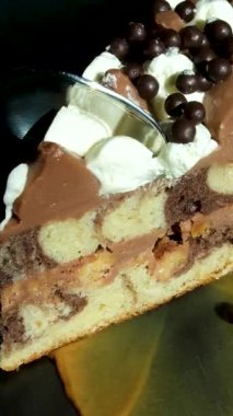 Çikolata traşı bir dilim meyveli kekin üzerine düşüyor, yavaş çekim 500 fps 'de dönüyor. Yüksek kalite 4k görüntü