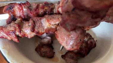 Kömürde kavrulmuş et. Eti şiş kebap üzerine şiş kebap yap.