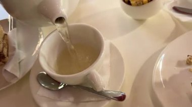 Turunçgil çayını yakın plan bardağa dolduruyorum. Nane ve portakallı taze bitki çayı, sağlıklı bir sabah, detoks içeceği. Yüksek kalite 4k görüntü