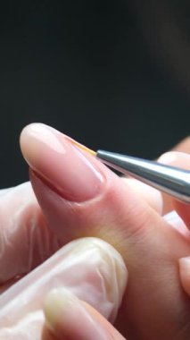 Jel cilası manikür, adım adım video eğitimi. Tırnak cilası. Kadın mor jel cilasını sürüyor ve tırnaklarını serbest bırakıyor. Kendin için ev yapımı manikür. Yüksek kalite 4k görüntü