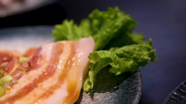 Taş tabakta dilimlenmiş çiğ domuz eti, beyaz arka planda izole edilmiş. Yüksek kalite fotoğraf