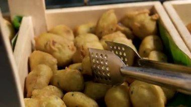 Erkek aşçının elinde maşayla beyaz tabağa kızarmış patates kızartması koyarken yaklaş. Yüksek kalite 4k görüntü