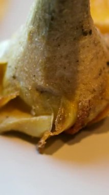 Enginar limon sosu. Bir tabak çiçeğin üzerinde yenilebilir sarı pahalı restoran enginarı yüksek kalite 4K görüntü.