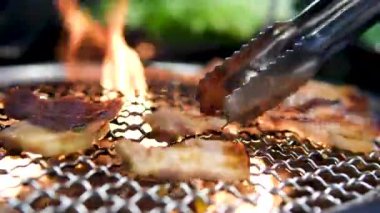 Hamburger, sosis ve sebzeleri kömür ocağında ızgara yapan bir adam. Yaz mangalı, açık hava yemekleri ve yemek temaları için mükemmel. Yüksek kalite fotoğraf