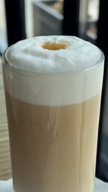 Restoranda kahve karıştıran köpüklü kızı yakalamak için çay kaşığı kullan. Yüksek kalite 4k görüntü