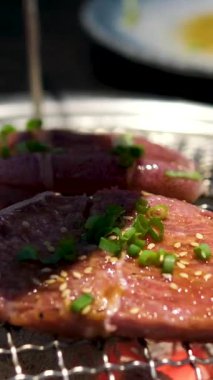 Yakın plan çekimleri, dumanlı ızgarada etleri ustalıkla çevirme, bulanık doğal arka plana karşı ayarlama. Yüksek kalite fotoğraf