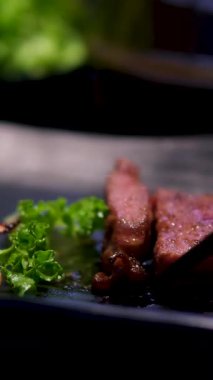 Izgara kalamar parçaları ve karışık ızgara et tabağı. Sığır eti, domuz eti, kümes hayvanları, sosis, ızgara sarımsak, kırmızı biber, ahşap arka planda kırmızı domates. Yüksek kalite fotoğraf