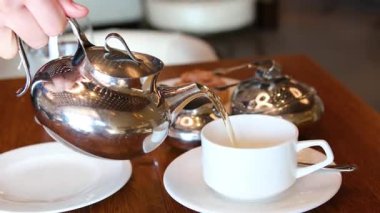 Geleneksel Fas çay servisi gümüş çaydanlık, çay fincanı ve servis tepsisi sunar. Sahne, Fas 'ın zengin kültürünü ve konukseverliğini çağrıştırıyor. Seyahat, kültür ve yaşam tarzı içeriği için mükemmel.. 