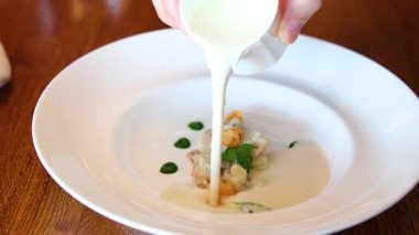 Süt çorbası ve deniz ürünleri sunumu. Garson sofrada kremalı çorba servis ediyor. Yemek dağıtımı, restoran reklamları, yemek reklamları ve servis sektörü tanıtımları için harika.. 