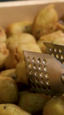 Erkek aşçının elinde maşayla beyaz tabağa kızarmış patates kızartması koyarken yaklaş. Yüksek kalite 4k görüntü