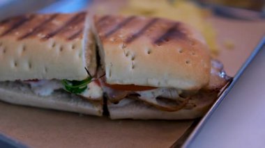 Fırında erimiş peynirli sandviç ve tabakta ikiye bölünmüş panini sandviçi. Kızarmış peynir. Yüksek kalite 4k görüntü